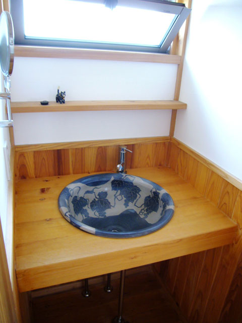 益子焼ボウルを使用した洗面台は、桧のカウンターと立ち水栓を