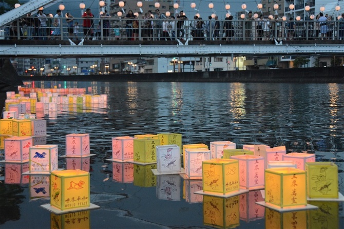 故人をしのぶ灯籠が連なる佐世保川。橋の上から外国人も見物した