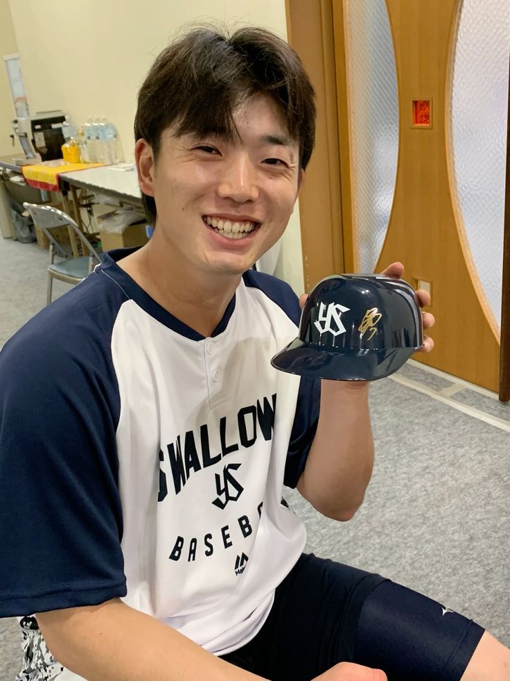 ひでちっぷす用のミニヘルメットにサインする長岡秀樹。