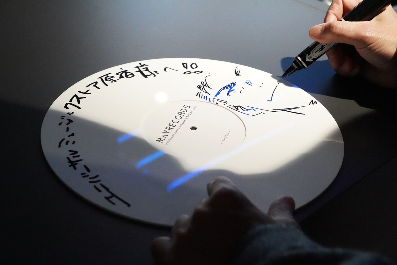 サインをする石塚真一。大と雪祈を描き下ろした。 [画像・動画